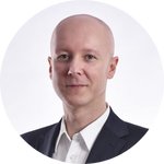 Leszek Szafrański, łysy mężczyzna w garniturze, lekko się uśmiecha.
